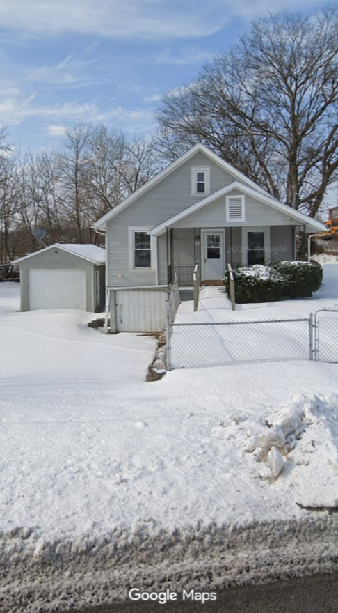 A home in Lanesville, Indiana, on a calm winter day before the flood, with its yard, garage and fence covered in snow.